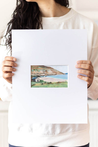 woman holding a landscape acrylic painting on a large mat