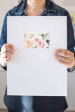 woman holding a watercolor flowers painting on a white frame