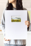 woman holding a landscape watercolor painting on a large mat - Flavia Bennard