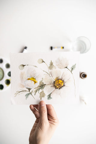 Flavia Bennard hand holding a white watercolor flowers painting