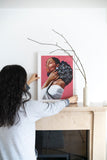 Pink-painting-of-black-woman-with-flowers-in-her-hair-on-mantel