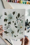 hands holding a loose watercolor flowers painting
