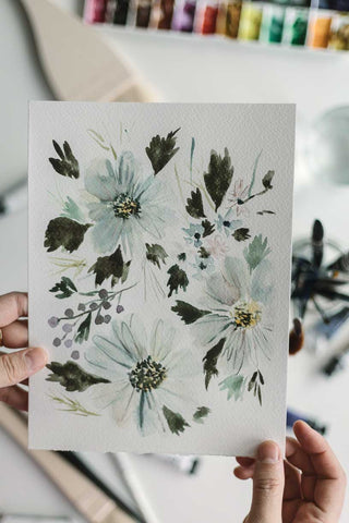 hands holding a loose watercolor flowers painting