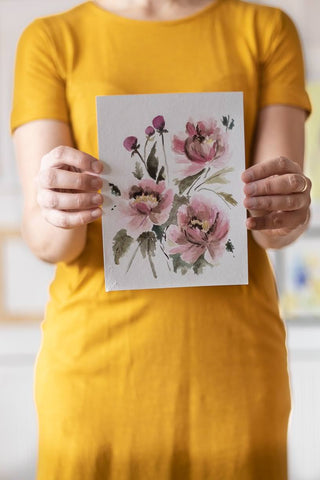 woman holding a pink watercolor flowers painting Flavia Bennard