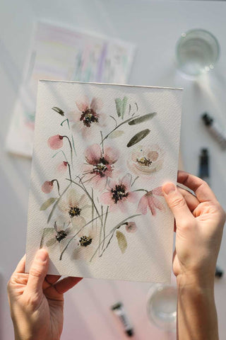 hands holding a loose watercolor flowers painting Flavia Bennard